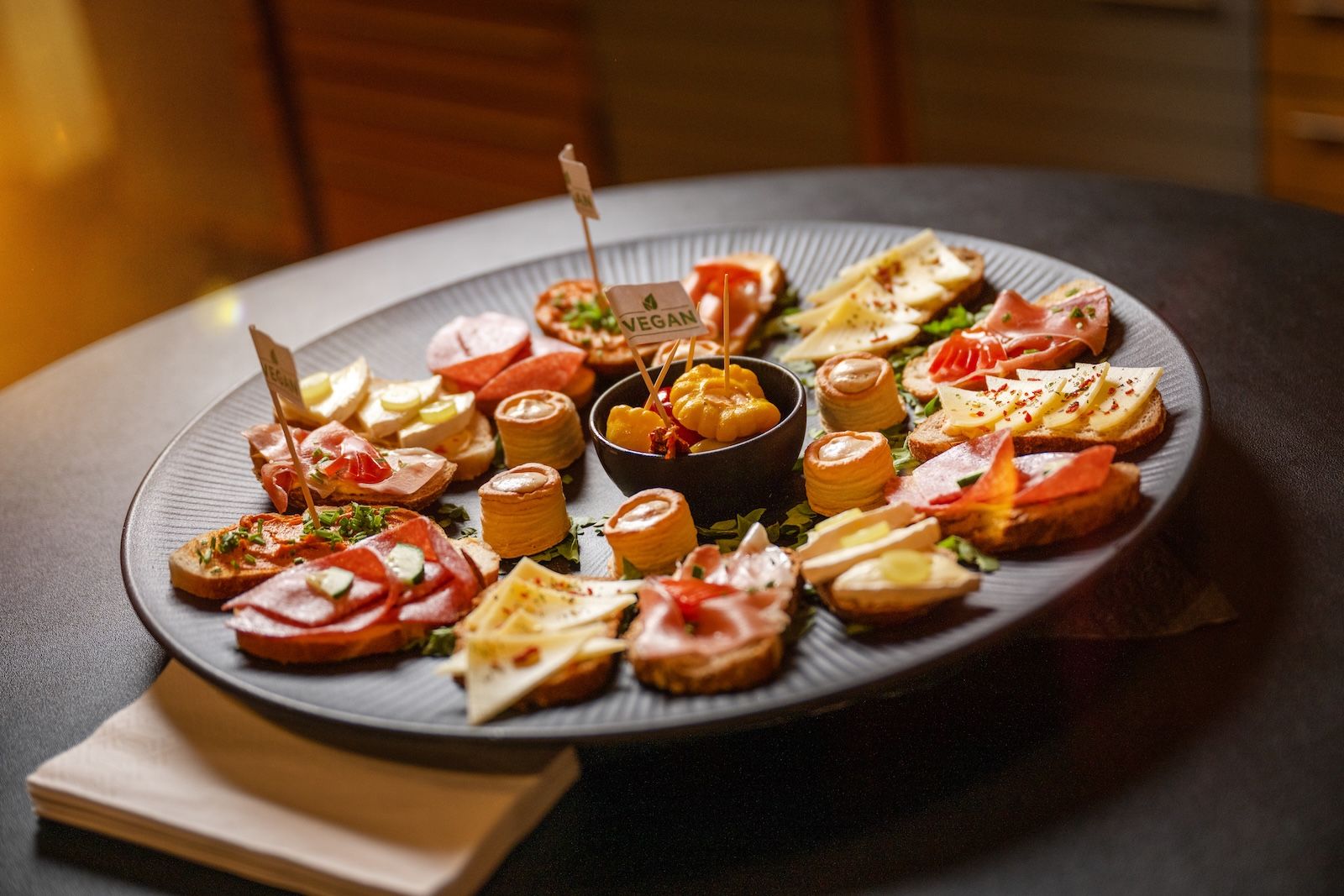 Kleine Schälchen mit goldbraun gerösteten Kartoffelspalten, angerichtet in knusprigen Teigkörbchen und mit frischen Kräutern verfeinert.